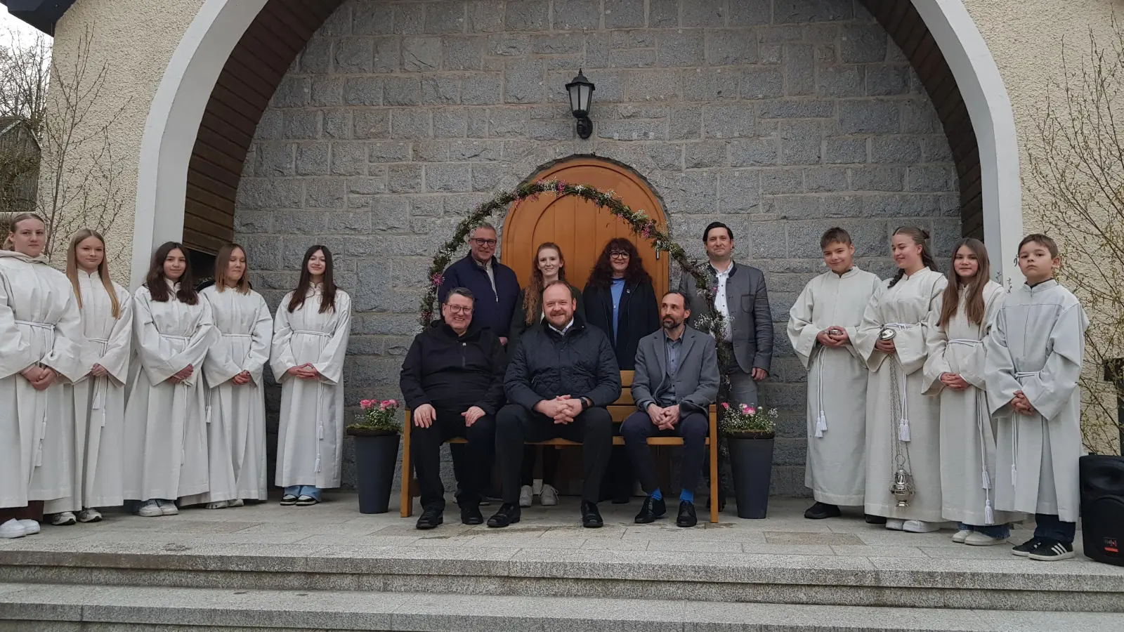 Nach der Segnung hatten die Ehrengäste mit Pfarrer Udo Klösel, Landrat Andreas Meier und Bürgermeister Armin Buldenda auf dem neuen „Hutzabankerl“ Platz genommen. Dahinter Kreisrat Helmut Meindl, Linda Weismeier und Barbara Mädl vom Forum Neustadt Plus sowie Marktgemeinderat Thomas Kleber, Heumaden (jeweils von links).  (Bild: Peter Garreiss)