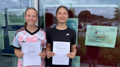 Elena und Julia mit den ausgefüllten Arbeitsblättern zur Ausstellung „Glänzende Aussichten“ (Bild: Doris Jentsch)