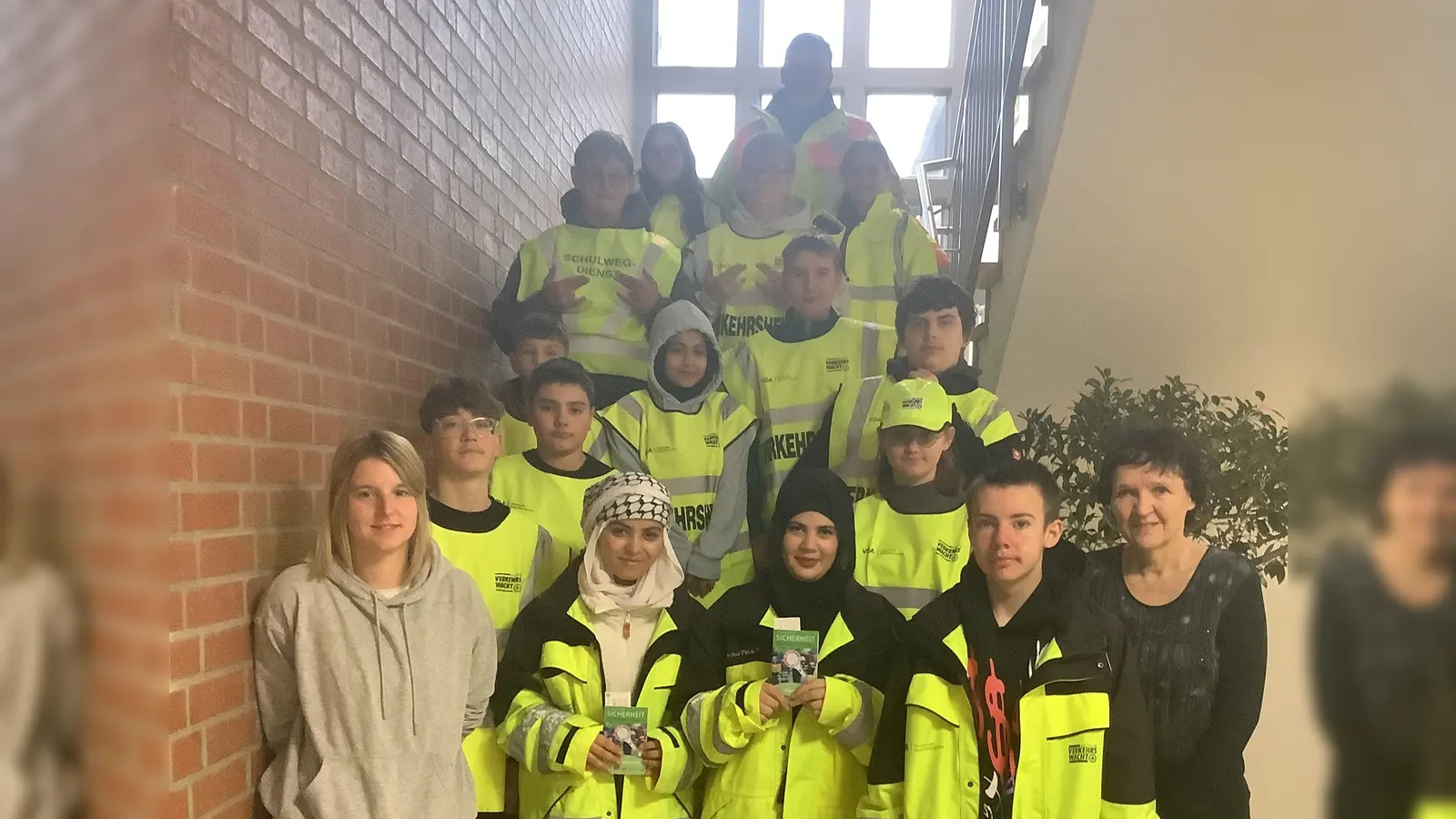 Nach der Ausbildung durch Polizeihauptmeister Paul Zawal sichern die neuen Lotsinnen und Lotsen (im Vordergrund) den Übergang in der Wollauer Straße. Koordiniert werden die Einsätze von Lehrerin Johanna Seifert, Schulleiterin Ulrike Neiser freute sich über das Engagement. (Bild: Hans Walter)