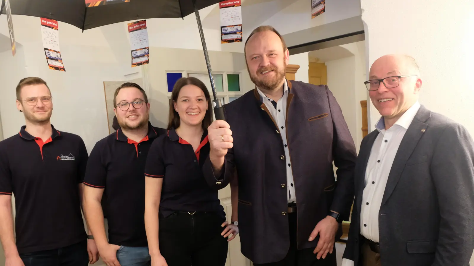 Symbolisch beförderte die Tremmersdorfer Feuerwehrführung mit Andreas Hubmann, Jonas Schleicher und Helena Diepold (von links) mit der Überreichung des Festschirms an den Landrat und seinen Stellvertreter zu Schirmherren des Feuerwehrjubiläums. (Bild: Robert Dotzauer)