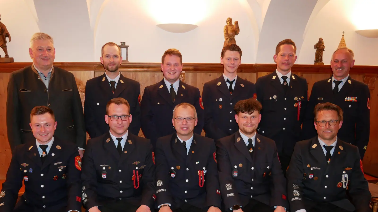 Kommandant Tobias Tippmann (sitzend, rechts) und 2. Bürgermeister Markus Scharnagl (stehend, links) mit den beförderten Feuerwehrmännern und dem scheidenden Kreisbrandmeister Wolfgang Fischer (stehend, rechts). Sein Nachfolger wird Felix Kubitschek (sitzend, zweiter von rechts). (Bild: Florian Müller)