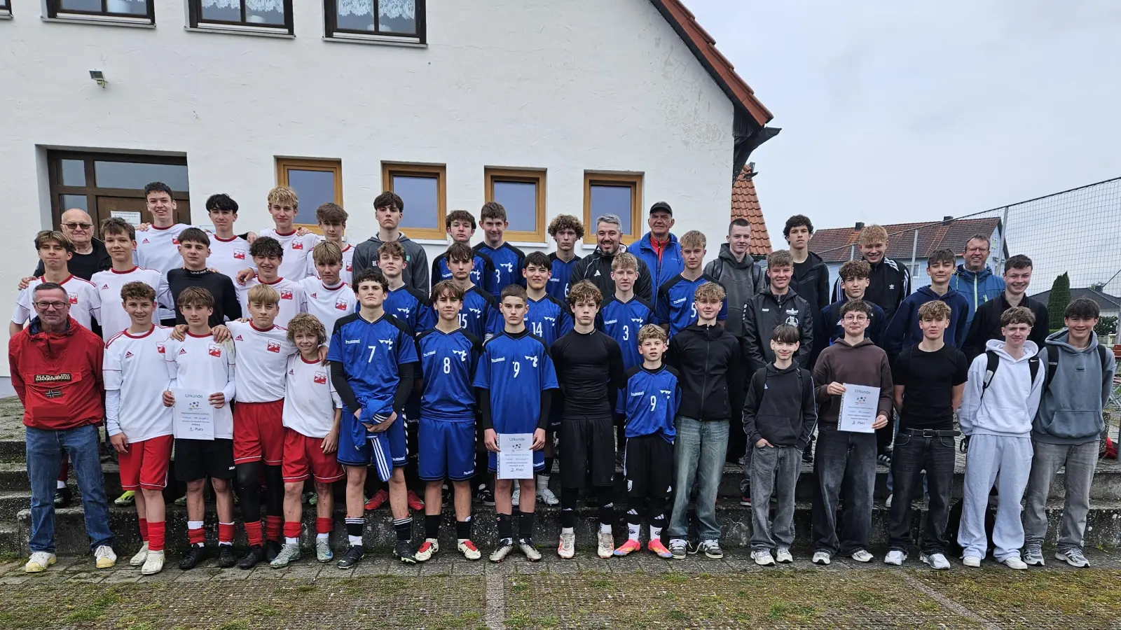 Auf dem Bild die Mannschaften der Altersgruppe Jungen II nach dem Regionalentscheid auf dem Sportgelände des FV Vilseck von links: 1. Farnz-Xaver-von-Schönwerth-RS, 2. Willibald-Gluck-Gymnasium und 3. Walter-Höllerer-RS Sulzbach-Rosenberg mit (hinten, von links) Karl Heinz Grollmisch, Studienrat Mahir Emonds (Neumarkt), Schiedsrichter Reinhard Wiesmeth, Studienrat Markus Binder (Su-Ro) sowie vorne links Studienrat Peter Luschner (Amberg). <br> (Bild: Karl Heinz Grollmisch)