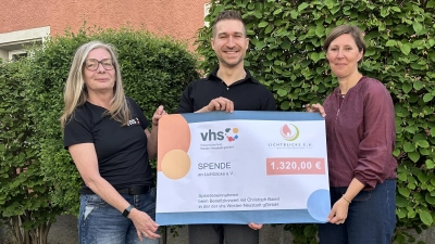 Dagmar Bock (links) von der Volkshochschule und Sänger Christoph Baierl übergeben an Viola Vogelsang-Reichl von der Aktion „Lichtblicke” einen symbolischen Scheck mit dem Erlös aus dem Benefizkonzert. (Bild: Tanja Pappenberger)