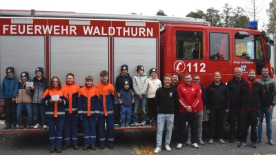 Fanclub-Vorstand Florian Scheck (6.v.re) übergab jeweils 350 Euro an die Kinderfeuerwehr Lennesrieth und die Jugendfeuerwehr Waldthurn. (Bild: Tanja Pflaum)