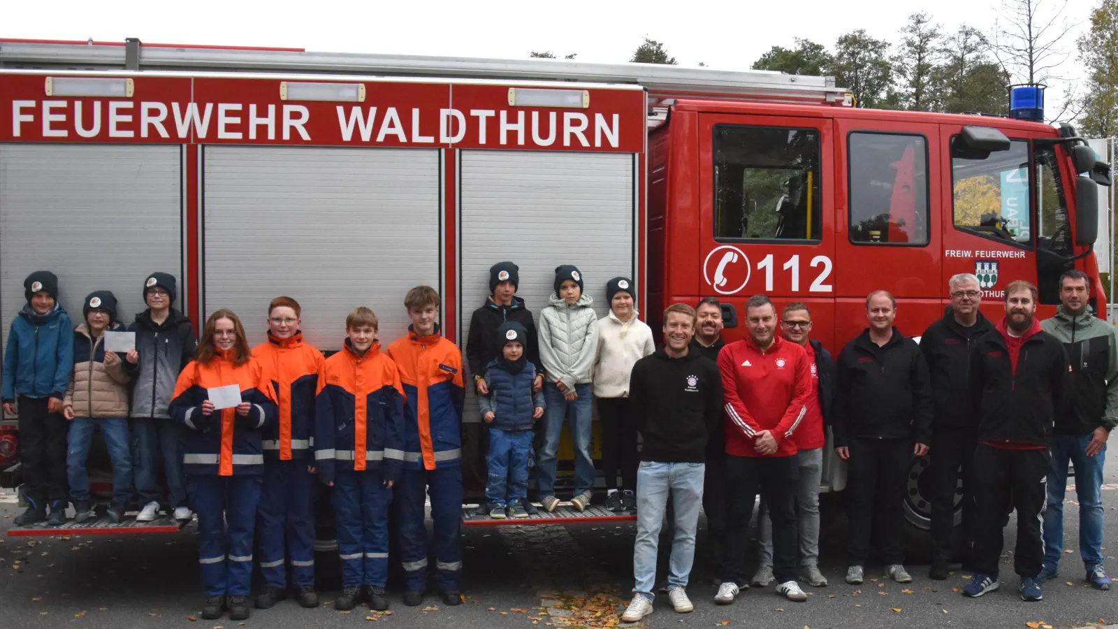 Fanclub-Vorstand Florian Scheck (6.v.re) übergab jeweils 350 Euro an die Kinderfeuerwehr Lennesrieth und die Jugendfeuerwehr Waldthurn. (Bild: Tanja Pflaum)