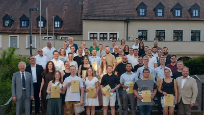 Die 40 Absolventinnen und Absolventen zusammen mit den Ehrengästen um Landrat Hubert Schicker (rechts) vor dem Landratsamt.  (Bild: Luisa Spitzl)