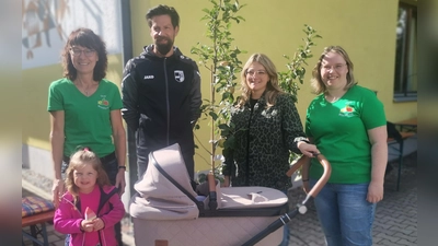Anita Dietl (links) und Nicole Spachtholz (rechts) übergeben den Apfelbaum an Familie Hutzler für ihre Tochter Tessa. (Bild: Annemarie Mösbauer)