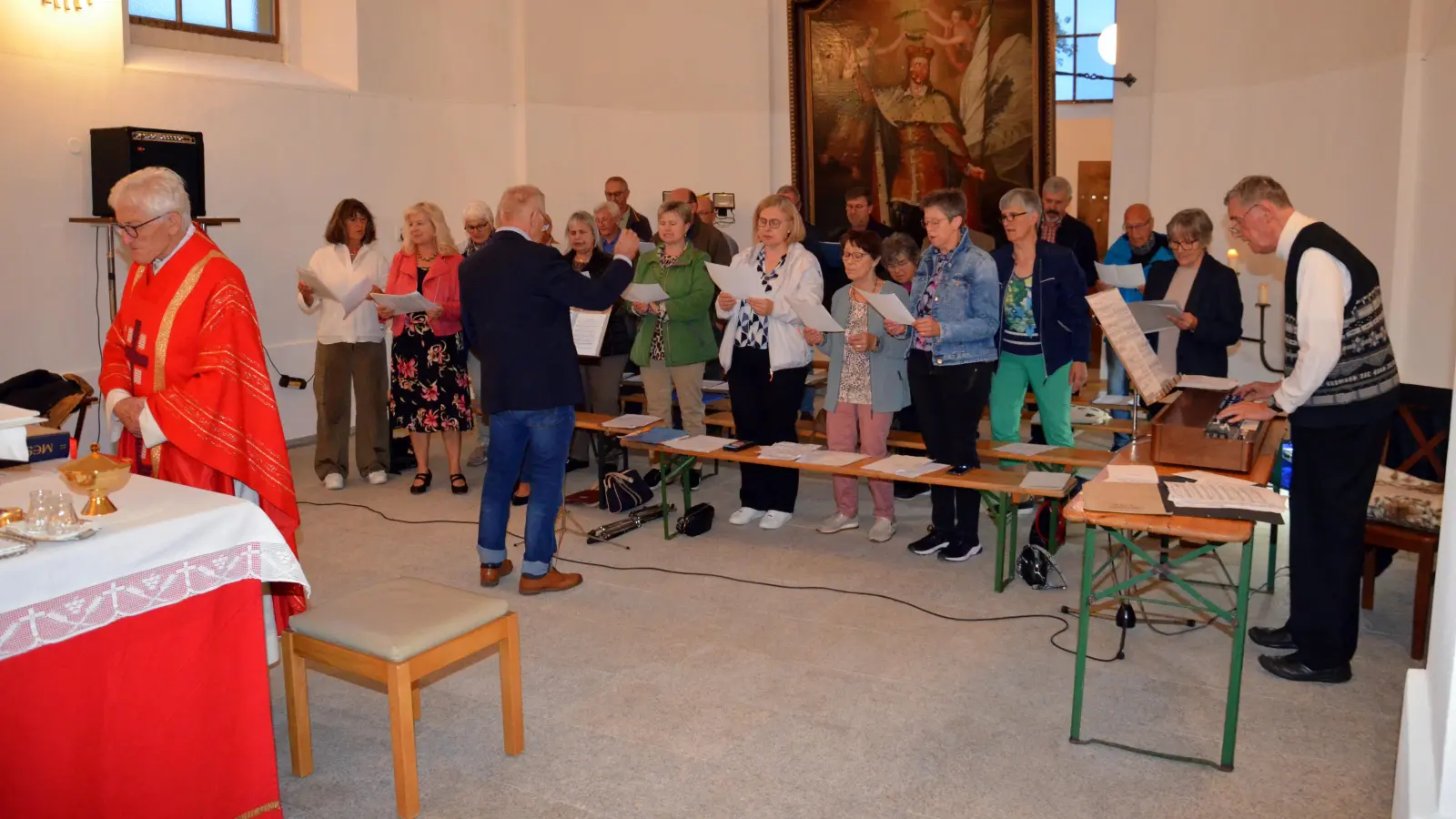 ganz links Pfarrer Georg Hartl, vor dem Chor der Dirigent Rudi Schneider, rechts Heribert Kett an der Orgel (Bild: Siegfried Zeug)