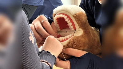 Zahnarztteam zeigt den Kindern wie man Zahnseide benutzt. (Bild: Laura Hackenberg)