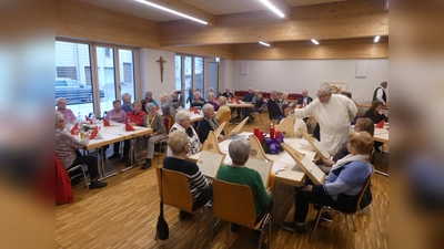 Pater Hermann Josef entzündete die Adventskerze. Mit Adventsweisen begleitete das Veeh-Harfen-Ensemble den Seniorennachmittag im Pfarrsaal. (Bild: Walther Hermann)