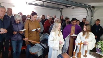Pfarrer Martin mit den Ministrantinnen und zahlreichen Gläubigen beim Schaueramt in der Garage der Familie Höcht. (Bild: Monika Selch)