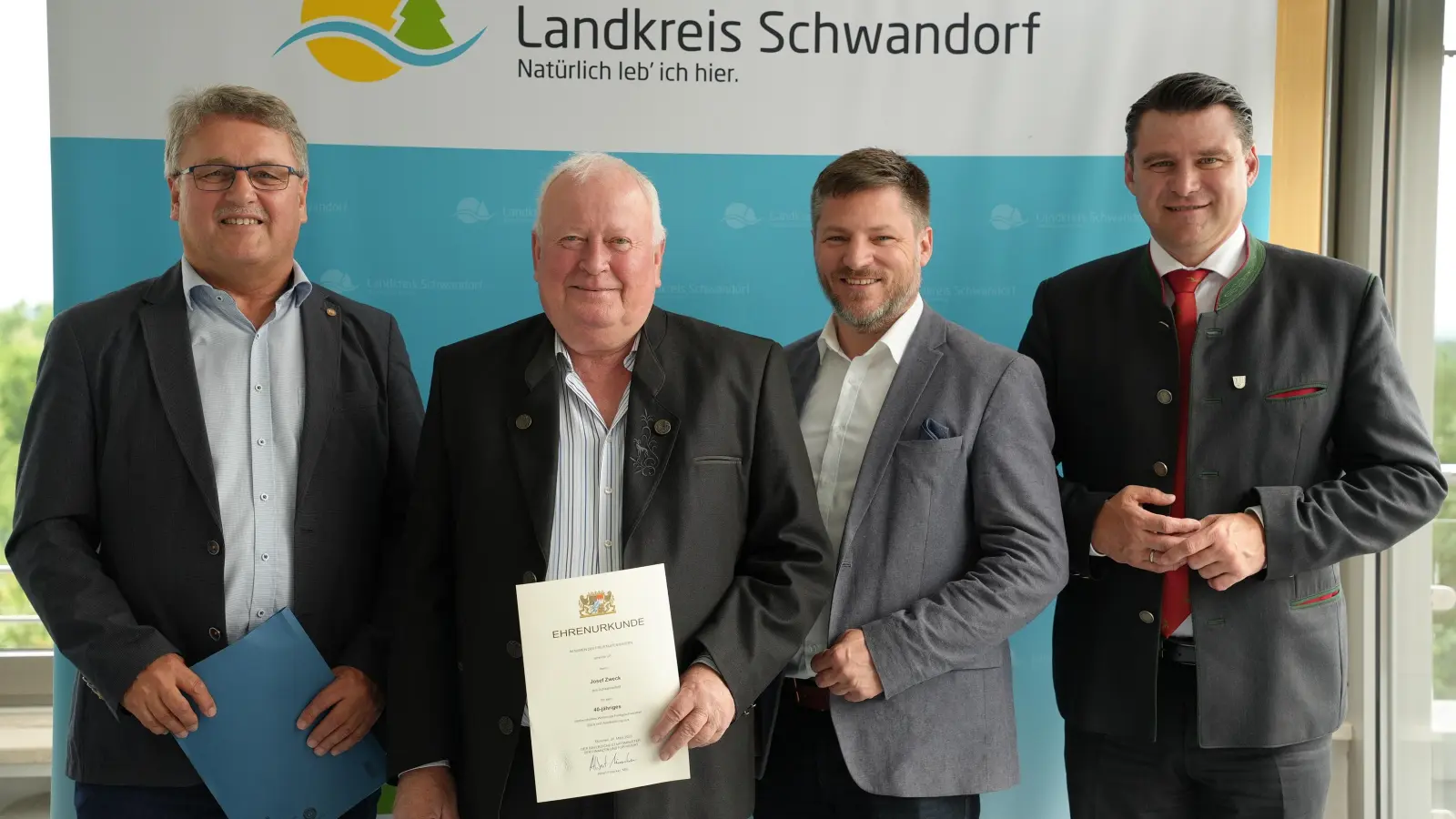 Landrat Thomas Ebeling (rechts), Peter Neumeier Bürgermeister von Schwarzenfeld (2.v.r.) und Christian Schmitz leitender Vermessungsdirektor (links) zeichnen Feldgeschworenen Josef Zweck (2.v.l) für 40 Jahre aus. (Bild: Laura Kohl)