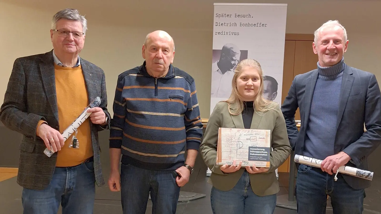 Karlhermann Schötz, Bernhard Neumann, Antonia Lingl mit Begrüßungsgeschenk, dem aktuellen Buch zur Fotografie im Lagerkomplex Flossenbürg, und Jörg Skriebeleit (v.l.n.r.).  (Bild: Timo Saalmann)