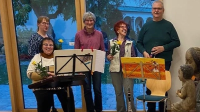 Im Vordergrund die feierlich geschmückte Madonna, im Hintergrund die erste Vorsitzende Doris Zeitler (3. von links) gemeinsam mit der Instrumentalgruppe St. Johannes, die die Andacht musikalisch gestaltete. (Bild: Ursula Schreier)
