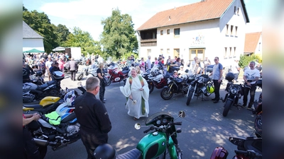 Pfarrer Albert Hölzl versprüht nach dem Motorradgottesdienst Freude und Weihwasser und segnet die Motorräder.<br> (Bild: Franz Völkl)