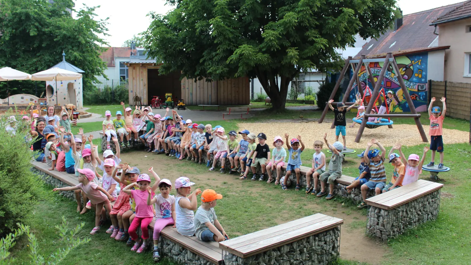 Die Kinder des Kindergarten St. Elisabeth in ihrem „grünen Gruppenzimmer” / Bolzplatz und die neue Schaukelanlage mit Drehwippteller (Bild: Stefanie Unterburger)