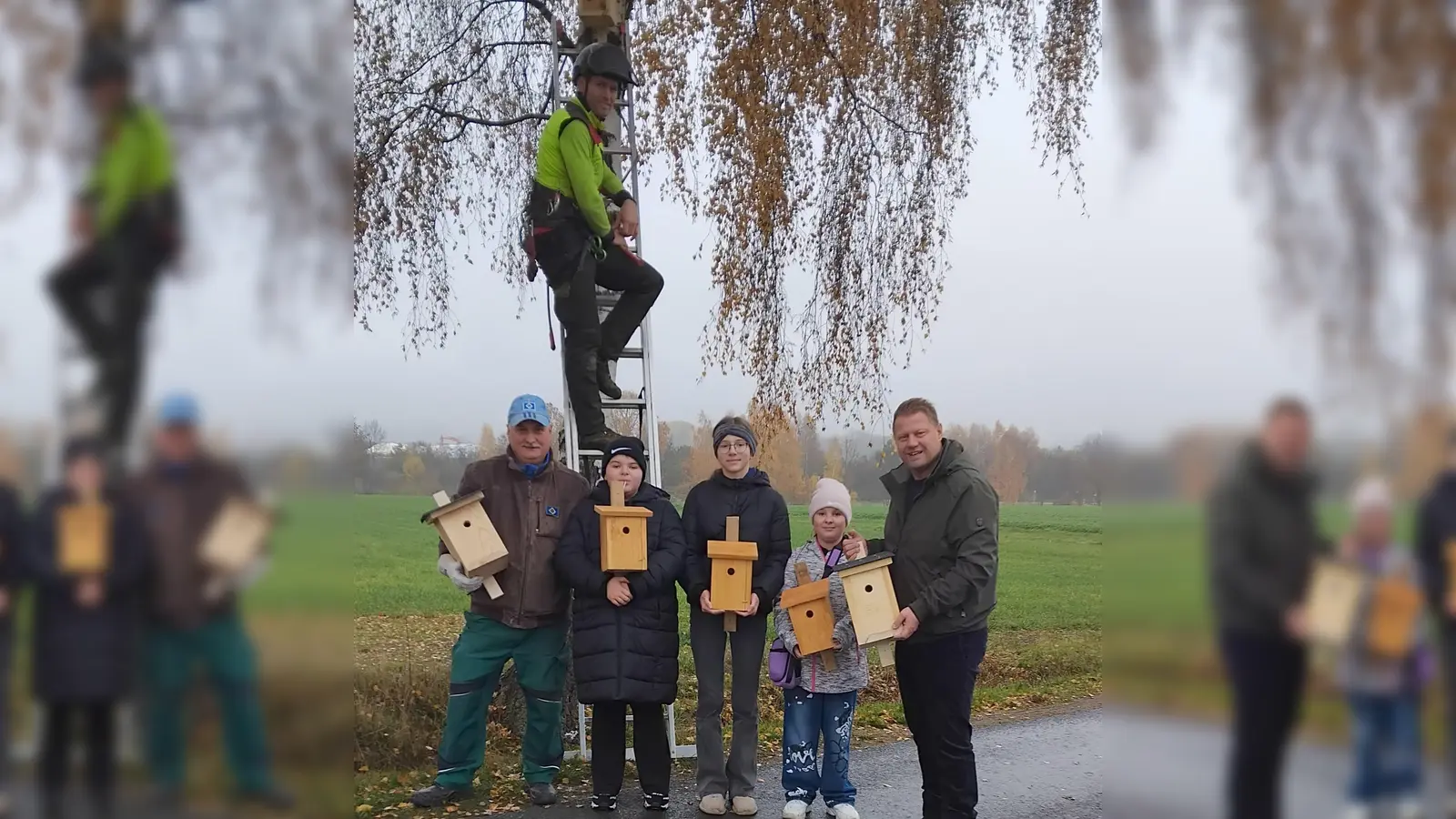 Übergabe der Nistkästen der Kolpingjugend. Bild von rechts - Bürgermeister Stefan Grillmeier, Kinder der Kolpingjugend, Stadtgärtner Willi Kilian und auf der Leiter Manfred Härtl (Bild: Johann Gruber)