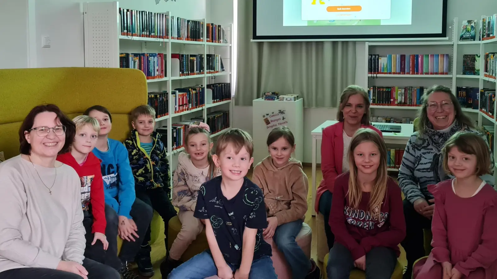 Silvia Mulzer (hinten, zweite von rechts) übernimmt für 2025 die Kosten für eine Onilo-Lizenz. Bibliotheksleiterin Petra Danzer (hinten rechts), Bibliotheksmitarbeiterin Sonja Schecklmann (vorne links) und die Kinder freuen sich über dieses tolle Geschenk. (Bild: Fiona Seemann)