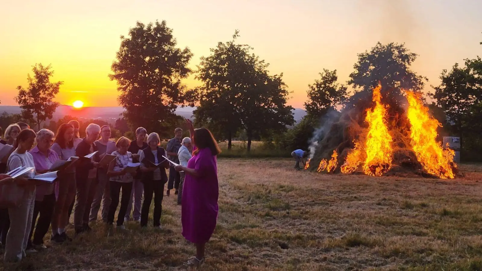 Chorissma vor dem loderndem Sonnwendfeuer und der untergehenden Sonne (Bild: Georg Hüttner)