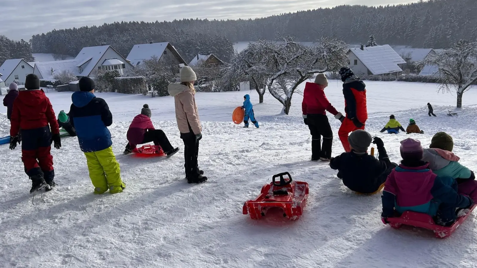 Die Grundschüler vergnügen sich bei herrlichem Winterwetter am Schlittenhang. (Bild: Christine Ruoff)