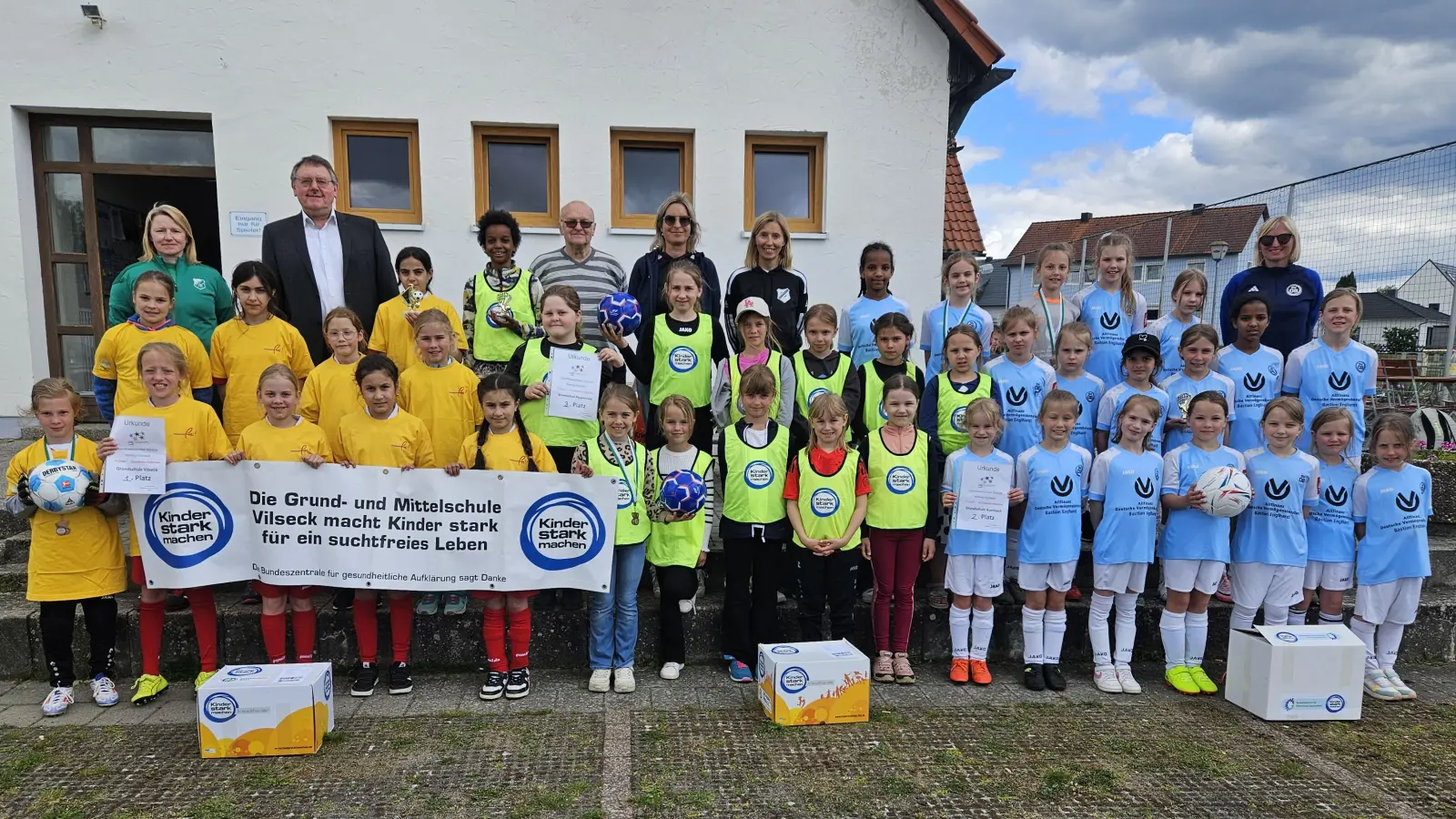 Die drei Mädchen-Mannschaften nach der Landkreismeisterschaft der Grundschulen auf dem Sportgelände des FV Vilseck von links: 1. Vilseck, 3. Poppenricht und 2. Auerbach mit (hinten, von links) Patricia Suttner, 1. Bürgermeister Hans-Martin Schertl, Karl Heinz Grollmisch, Rektorin Janina Schmidt und Susanne Engelhardt (beide Poppenricht) und Lehrerin Sabine Biersack (Auerbach). (Bild: Karl Heinz Grollmisch)