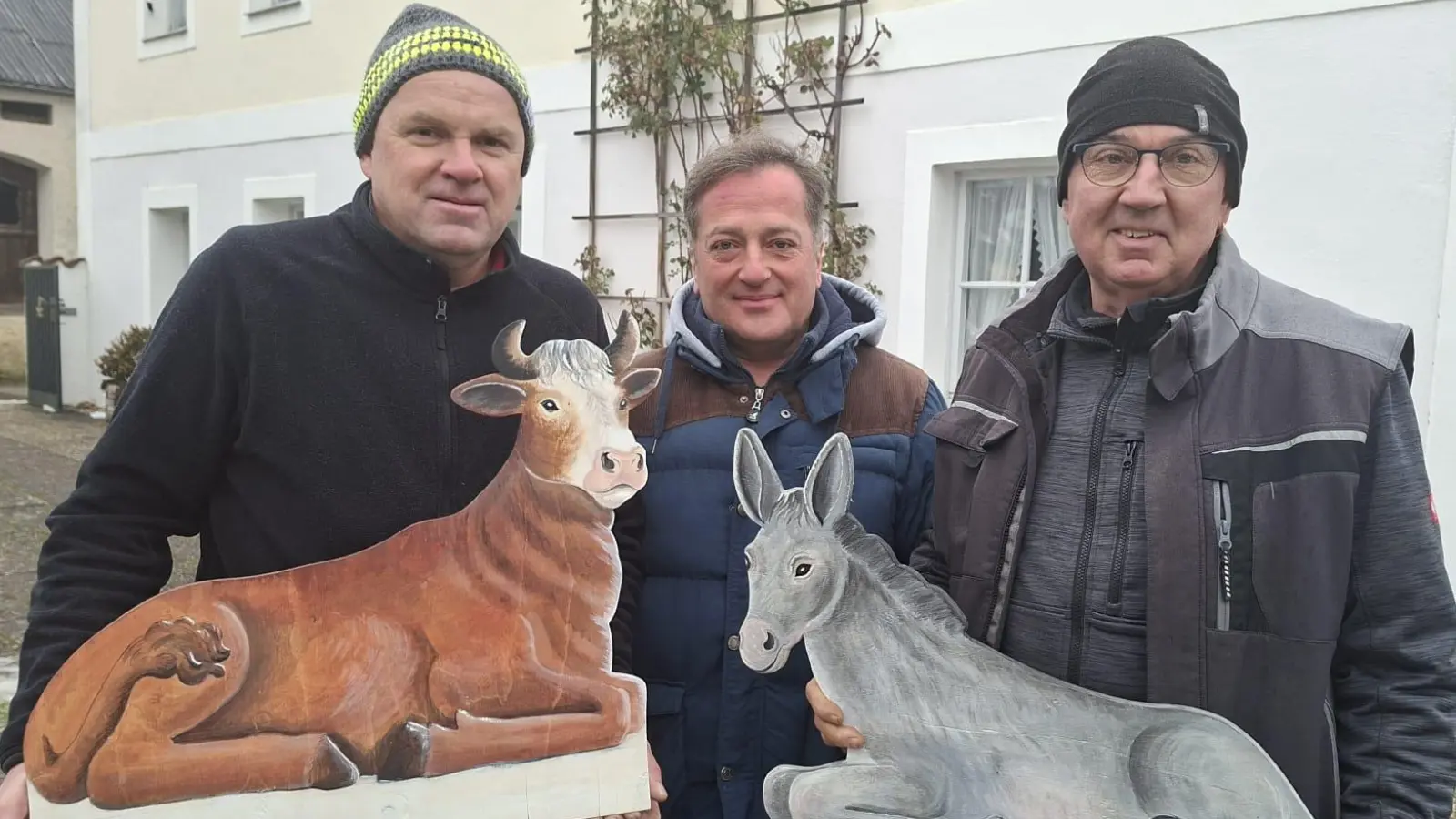 Ochs und Esel für die Krippe sind Handwerkskunst von Mesner Johannes Zeindl (m.) mit der tatkräftigen Unterstützung der Ministranten. Mit ihm freuen sich Josef Hollweck (l., Kirchenverwaltung) und Christian Bauer (r., Kirchenpfleger). (Bild: Marion Hollweck)