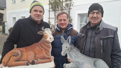 Ochs und Esel für die Krippe sind Handwerkskunst von Mesner Johannes Zeindl (m.) mit der tatkräftigen Unterstützung der Ministranten. Mit ihm freuen sich Josef Hollweck (l., Kirchenverwaltung) und Christian Bauer (r., Kirchenpfleger). (Bild: Marion Hollweck)