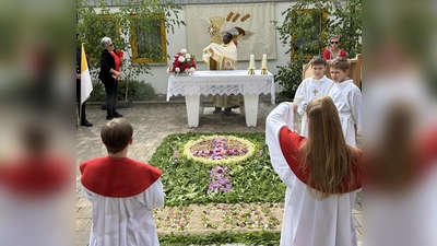 Am bunt geschmückten Blumenaltar am katholischen Kindergatren feierte Pfarrvikar Dr. Linus zusammen mit über hundert Gläubigen eine kleine Andacht. (Bild: Roman Melzner )