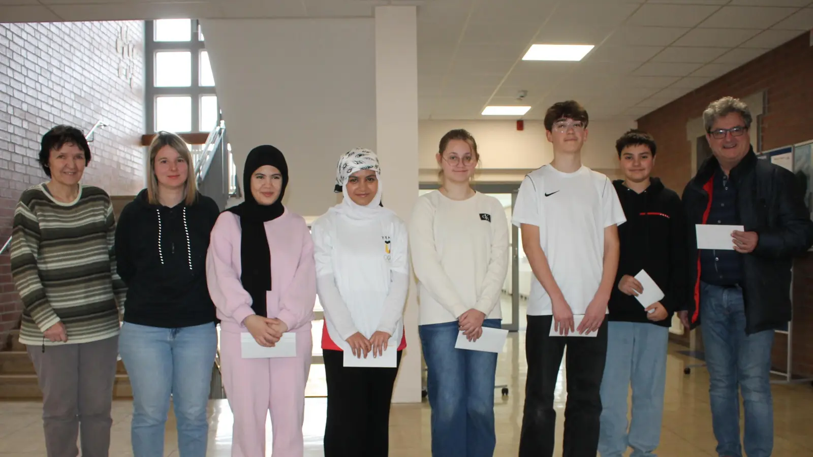 Die neuen Pressather Schülerlotsen (Dritte bis Siebenter von links): Mariam Alkhalaf, Lilasse Alsuisse, Barbara Hausner, Ensar Kovacevic, Naser Mekaca; nicht auf dem Bild Fabrice Heldmann. Von links Schulleiterin Ulrike Neiser, Lehrerin und Ansprechpartnerin für Verkehrserziehung Johanna Seifert. Rechts Bürgermeister Bernhard Stangl. (Bild: Bernhard Piegsa)