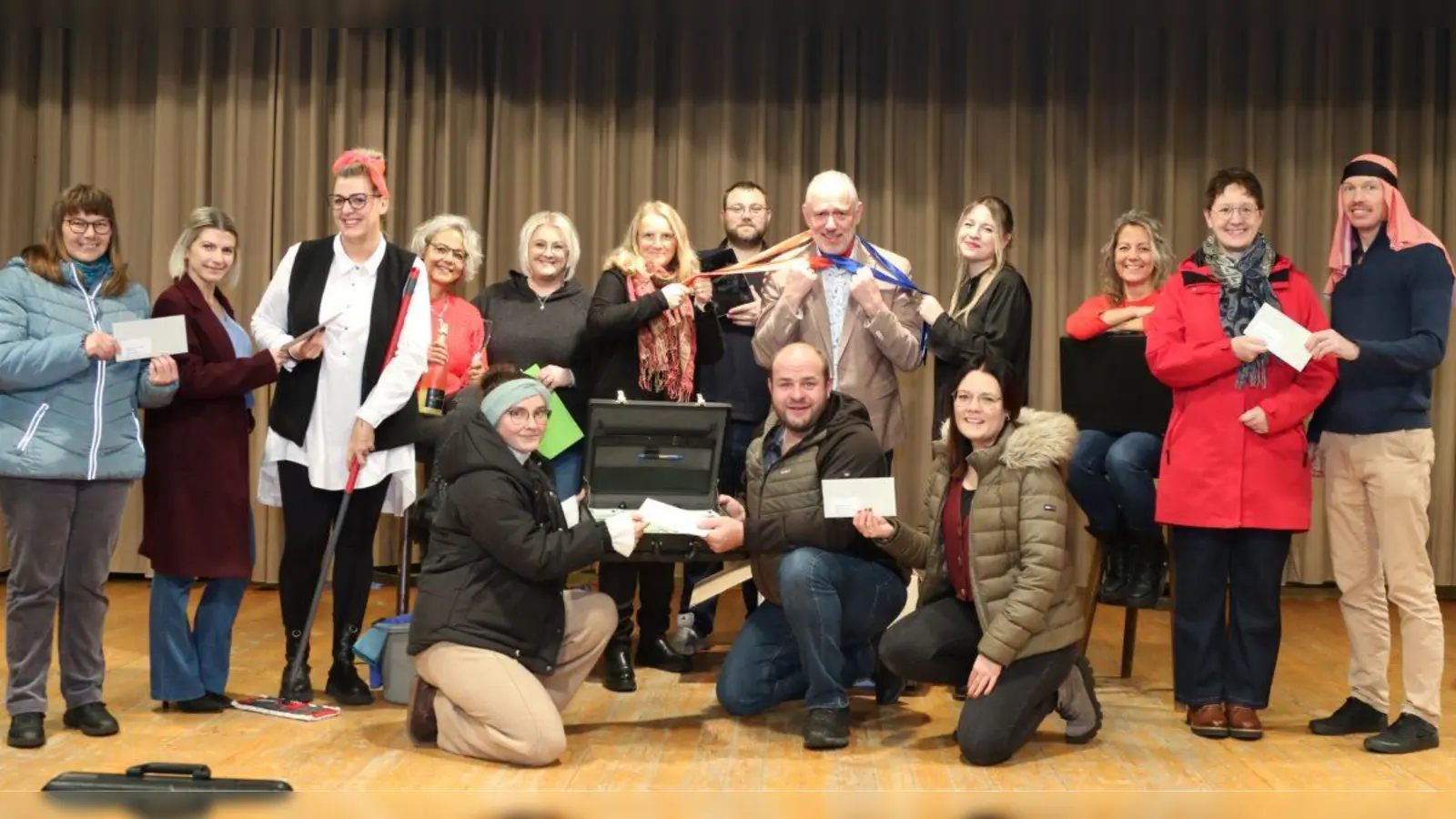 Das Foto zeigt die Akteure beim dritten Teil der Spendenübergabe. Hierzu hatten sich die verschiedenen Vertreterinnen der Bücherei “St. Michael” und der Grafenwöhrer Kitas “St. Theresia”, “Kunterbunt”, “St. Josef Hütten” und der SVE (Schulvorbereitende Einrichtung) eingefunden. Insgesamt kam ein Betrag von 3000 Euro zur Ausschüttung, der aus dem Erlös des Wintertheater 2025<br>mit dem Titel „Happy Birthday, Kate!“ stammt. (Bild: Theatergruppe Grafenwöhr)