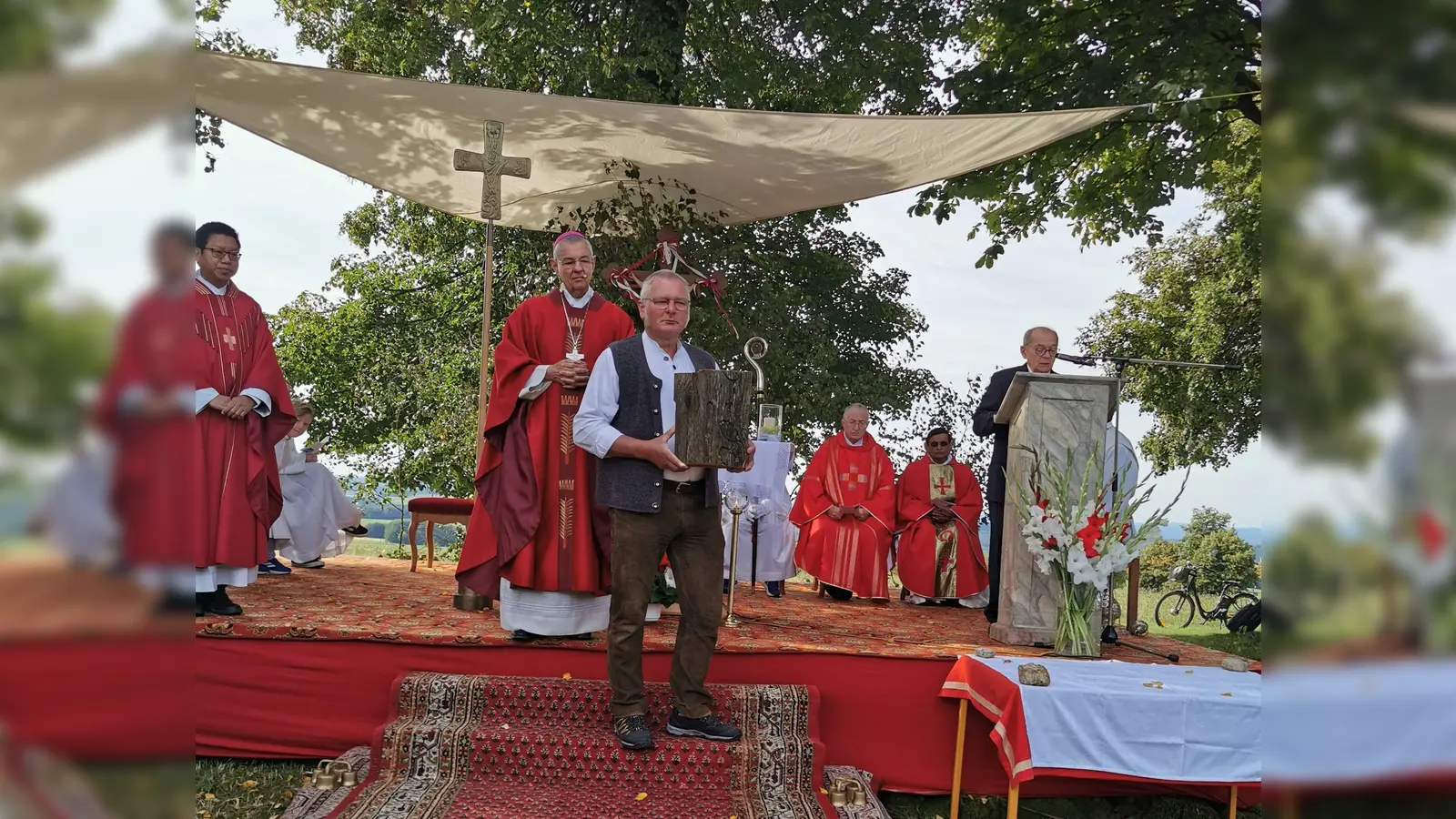Josef Schleicher hatte im Vorfeld das neue Kreuz gefertigt und präsentierte sinnbildlich ein Teil des früheren bei der großen Gabenprozession beim Einweihungsgottesdienst.  (Bild: Herbert Ziegler)