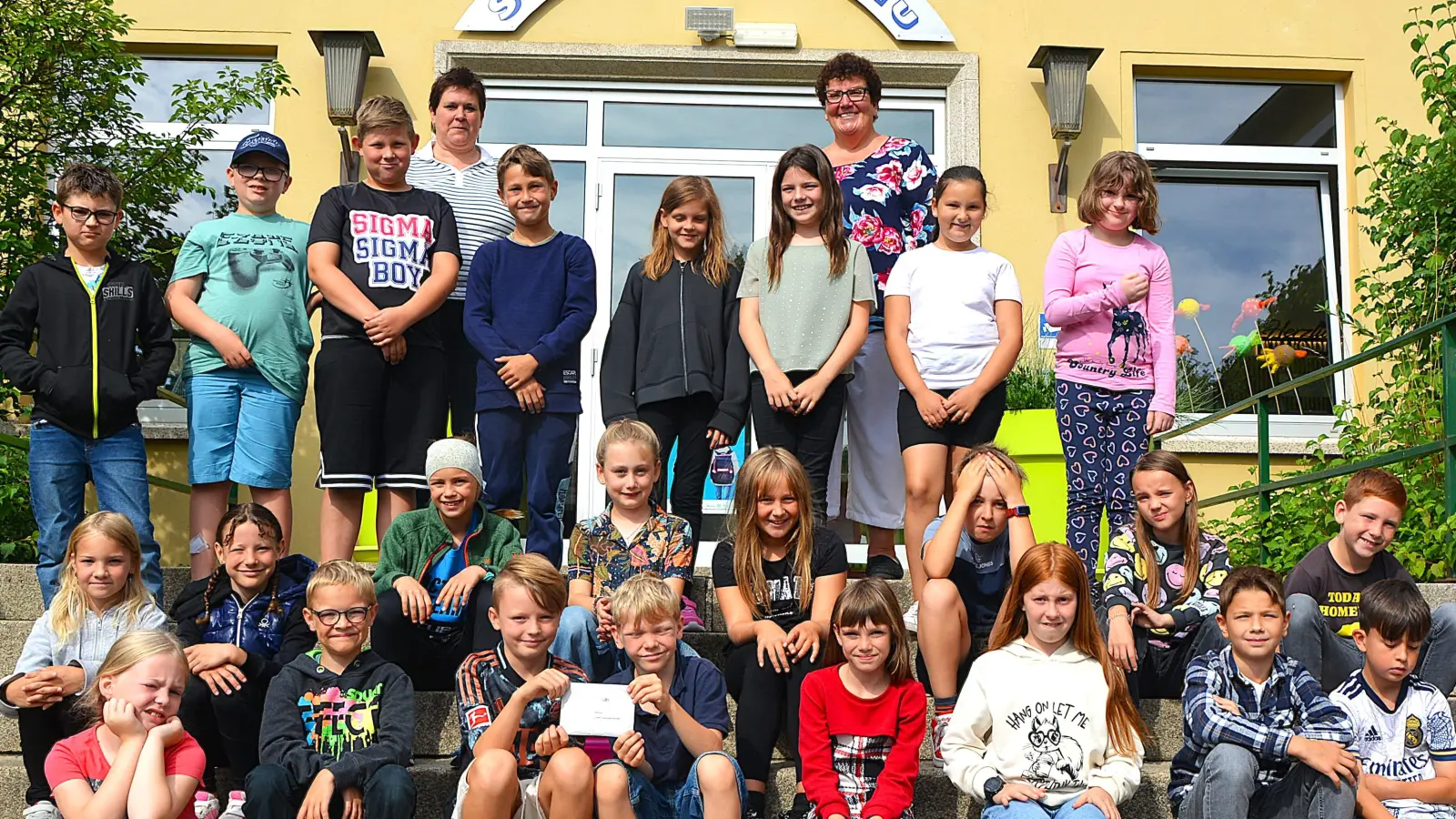 Die Hirschauer Kommunionkinder bei der Spendenübergabe vor der Hirschauer Schule. Li. hinten Gemeindereferentin Barbara Schlosser, re. hinten Karin Borchers von „Ninos Freunde”.  (Bild: Fritz Dietl)