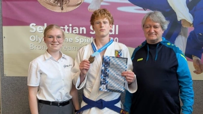 Nils mit Bronze zusammen mit Kampfrichterin Emma und Trainer Manfred Schmid. (Bild: Christian Heldmann)