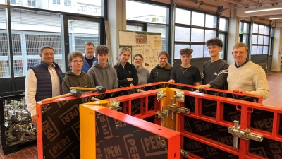 Stolz auf die selbst aufgebaute Schalung: Die Schüler des Augustinus-Gymnasiums – hier mit HWK-Geschäftsführer Alexander Stahl (li.), Leiter des Bildungszentrums Tobias Knauer (re.) und Ausbilder Karl Winkler (hinten). (Bild: Paul Bockholt)