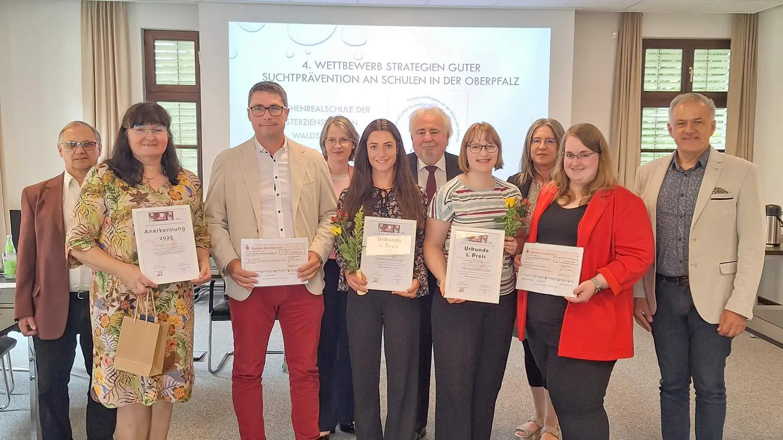 Große Freude bei den beiden Schulen: (v.l.) Stefan Geyer (Leiter Gesundheitsamt Tirschenreuth), Kamila Härtl, Suchtpräventionsfachkraft des Gesundheitsamts, Armin Aichinger (Schulleiter Grundschule Tirschenreuth), Schulamtsdirektorin Martina Puff, Schulsozialpädagogin Nadja Mark (Grundschule Tirschenreuth), Peter Gold für die Stadt Tirschenreuth, Vanessa Pentner, suchtpräventionsbeauftragte Lehrkraft der Mädchenrealschule Waldsassen, Kerstin Reiter (Schulleiterin MR Waldsassen) sowie Jugendsozialarbeiterin Kathrin Röthig und Landrat Roland Grillmeier bei der Preisübergabe.  (Bild: Fabian Polster)