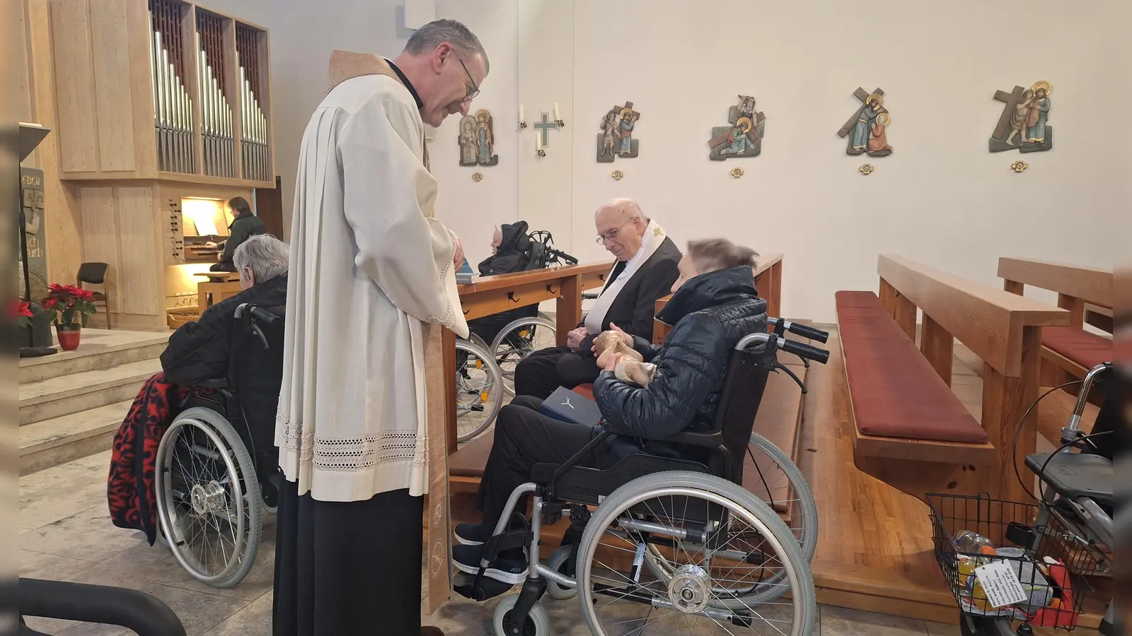 Behutsam legte Stadtpfarrer Dr. Thomas Vogl das Jesuskind in die Arme der Gottesdienstteilnehmer.  (Bild: Monika Grötsch)
