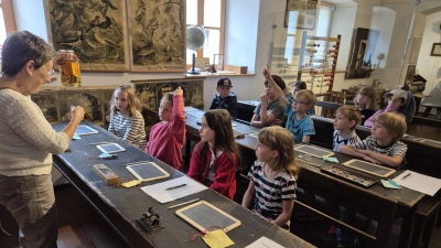 Gabriele Achmann versetzte die Kinder in die Zeit der ehemaligen alten Münchenreuther Dorfschule. (Bild: Hermann Müller)