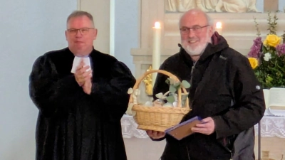 Pfr. Berthold gratulierte Martin Häupler für seinen langjährigen Dienst mit Urkunde und einem „musikalischen” Geschenkkorb (Bild: Franziska Berthold)