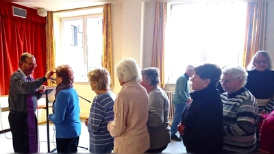 Pfarrer Thomas Stohldreier zeichnet das Aschenkreuz auf die Stirn der Senioren. (Bild: Sabine Bäumler)