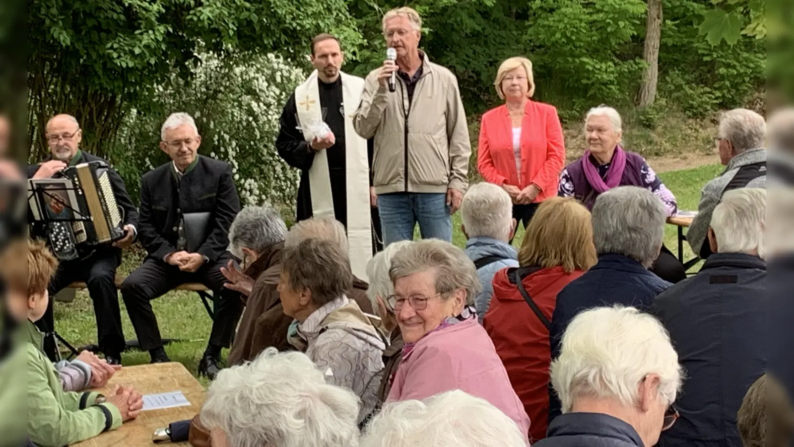 Seniorenbeauftragte Gabriele Beck (rechts stehend), 2. Bürgermeister Karl-Heinz Dausch (mitte stehende) und Pater Dominikus (links stehend) begrüßten alle über 100 Schwarzenfelder Senioren oben am Miesberg vor der Lourdes-Grotte zur Maiandacht.  (Bild: Silvia Beck)