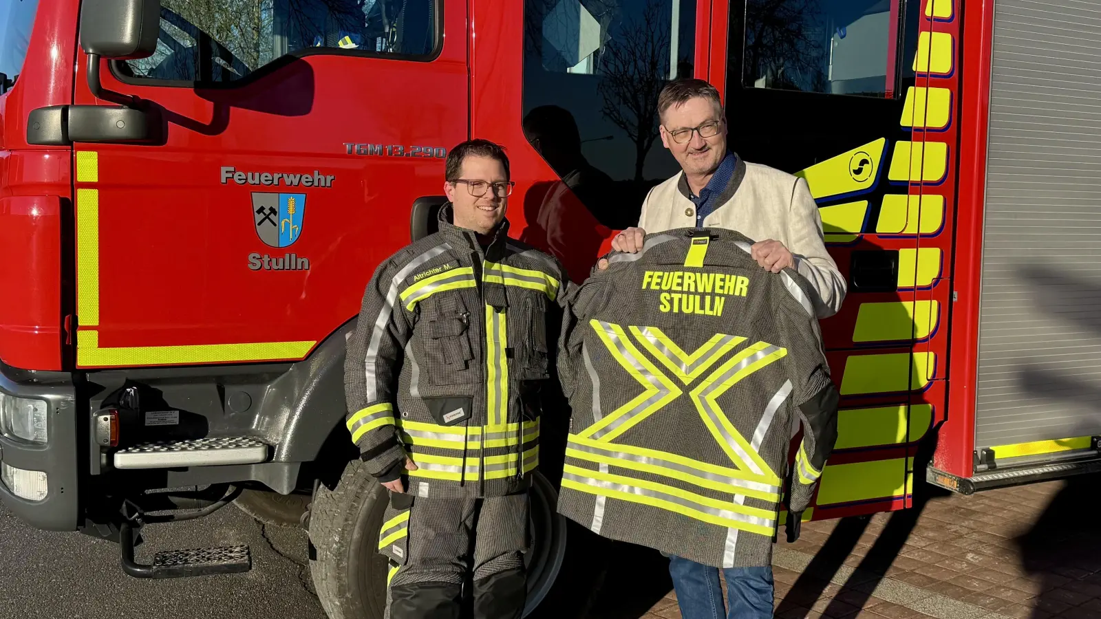Bürgermeister Hans Prechtl (rechts) und Kommandant Michael Altrichter mit der neuen Schutzkleidung der Freiwilligen Feuerwehr Stulln. (Bild: Tobias Reitmeier)
