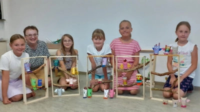 Die Kinder mit ihren Kunstwerken, den gebastelten Eulenhäusern mit der Leiterin der Gitarrengruppe Rita Butz (2. von links). (Bild: Sonja Binder)