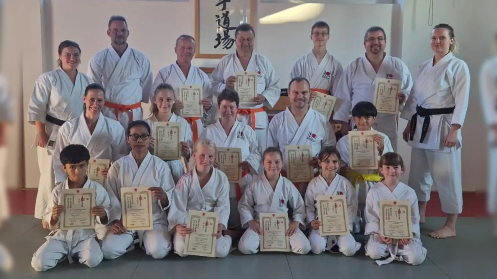 Prüferinnen Anna Schönberger (ganz rechts) und Renate Baier (ganz links) mit 15 Karate-Prüflingen (Bild: Michael Hirn)