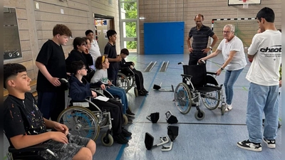 Beate Götz (2.v.r.) erklärt Schülern der Max-Reger-Schule Weiden den Umgang mit dem Rollstuhl (Bild: Stefanie Ram)