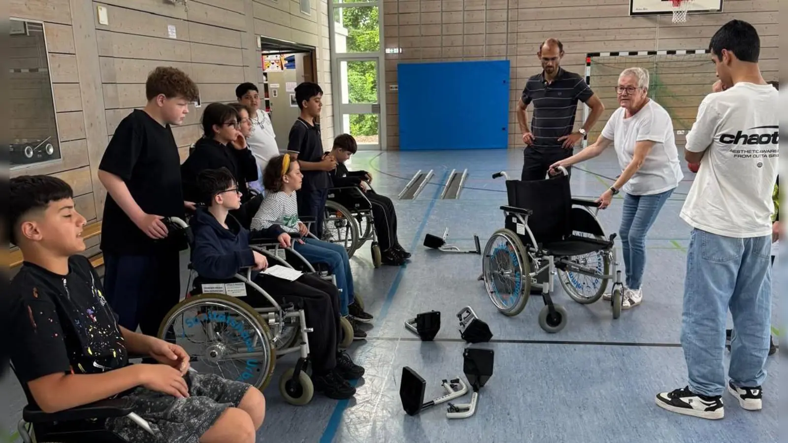 Beate Götz (2.v.r.) erklärt Schülern der Max-Reger-Schule Weiden den Umgang mit dem Rollstuhl (Bild: Stefanie Ram)