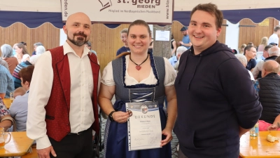 Alexandra Bauer erhielt eine Auszeichnung vom Nordbayerischen Musikbund von Erstem Vorsitzenden Sebastian Zapf (r.) und Dirigent Miroslaw Zgrzendek (l.) überreicht. (Bild: Michael Rabenhofer)
