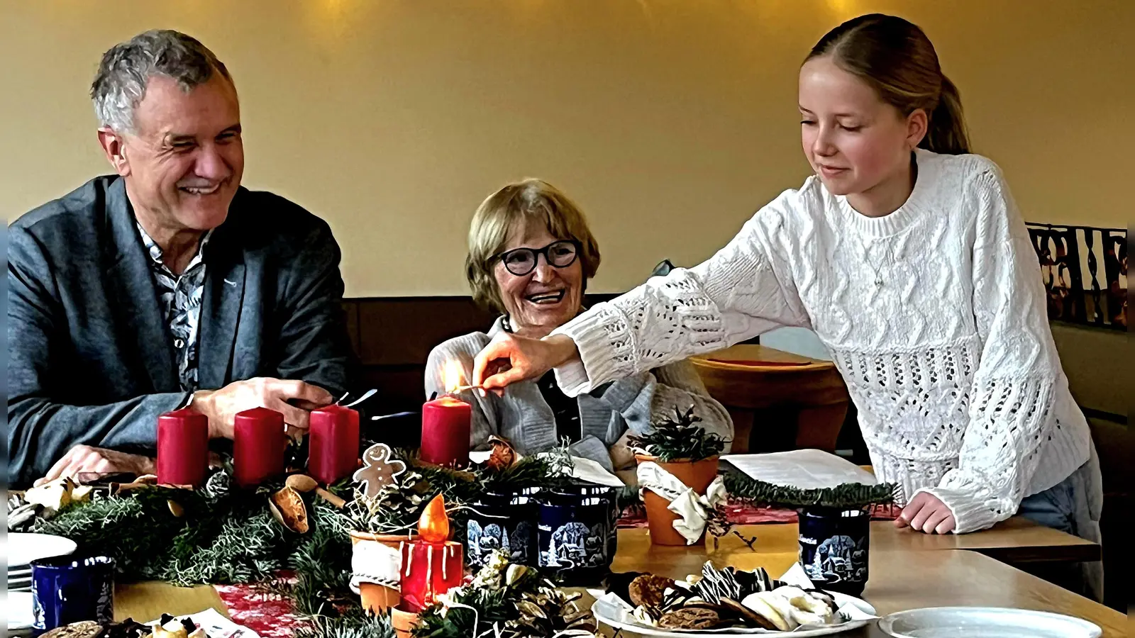 Stefanie Salavs-Lorenz entzündet die erste Kerze auf dem Adventskranz. Links im Bild Teamsprecher Hans-Jürgen Gmeiner. (Bild: Heinz Lorenz)