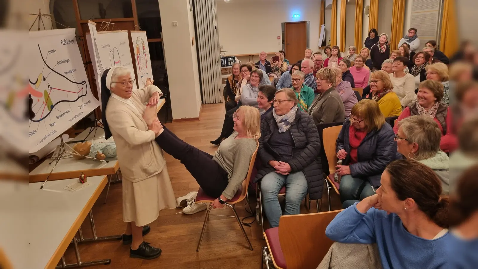 Schwester Jubilata zeigt die Druckpunkte an einer Freiwilligen (Bild: Evi Schreyer)