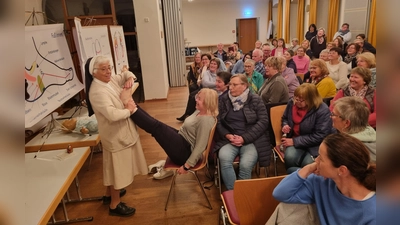 Schwester Jubilata zeigt die Druckpunkte an einer Freiwilligen (Bild: Evi Schreyer)