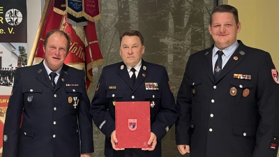 Die beiden Vorsitzenden Markus Dehling (links) und Simon Streher (rechts) ernannten Alexander Graf zum Ehrenmitglied der Feuerwehr Ursensollen. (Bild: Florian Schlegel)